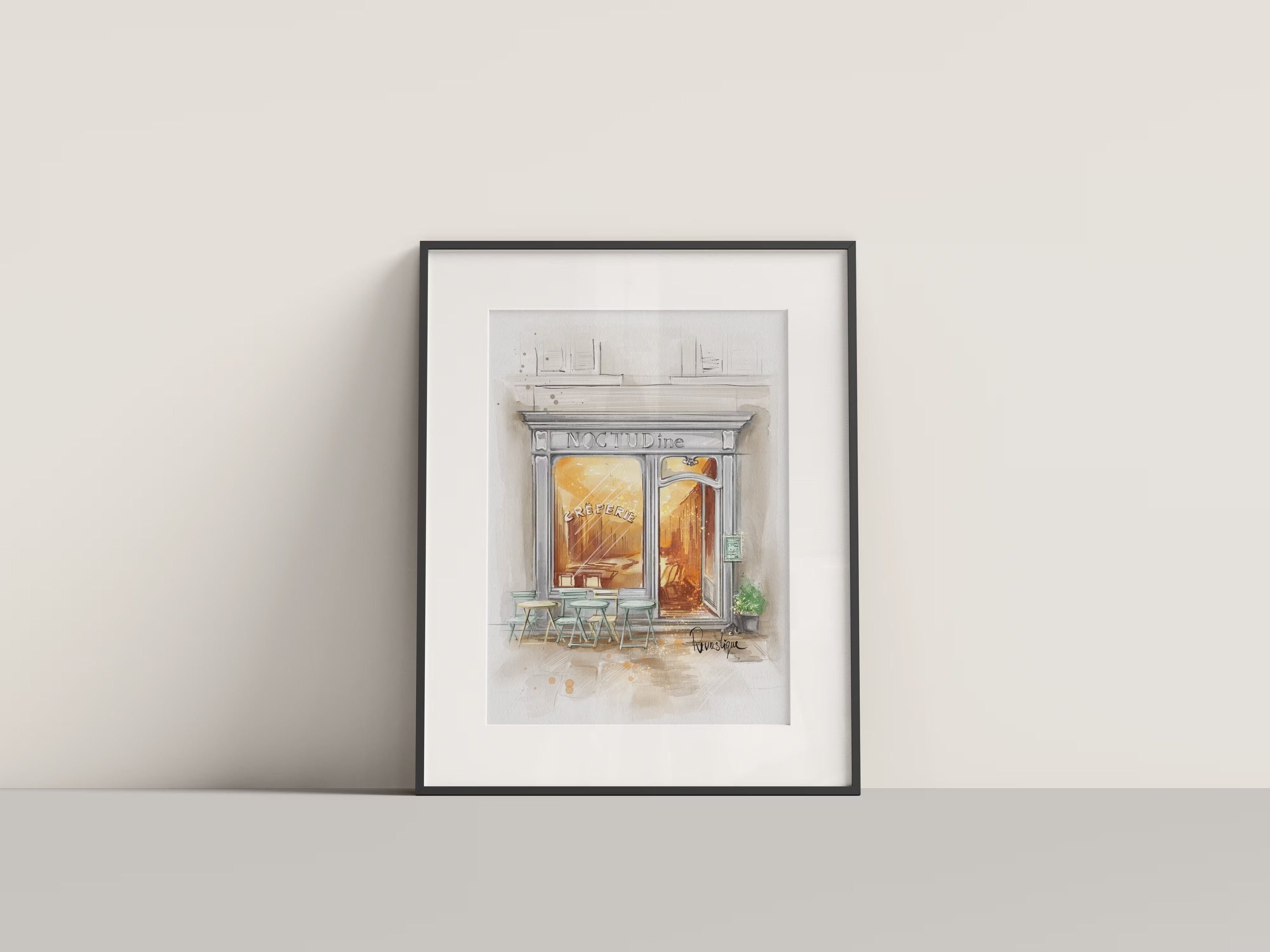 Framed watercolour illustration of a cosy French café storefront with warm amber glow, bistro tables and outdoor seating, custom business portrait artwork by Revastique Auckland New Zealand