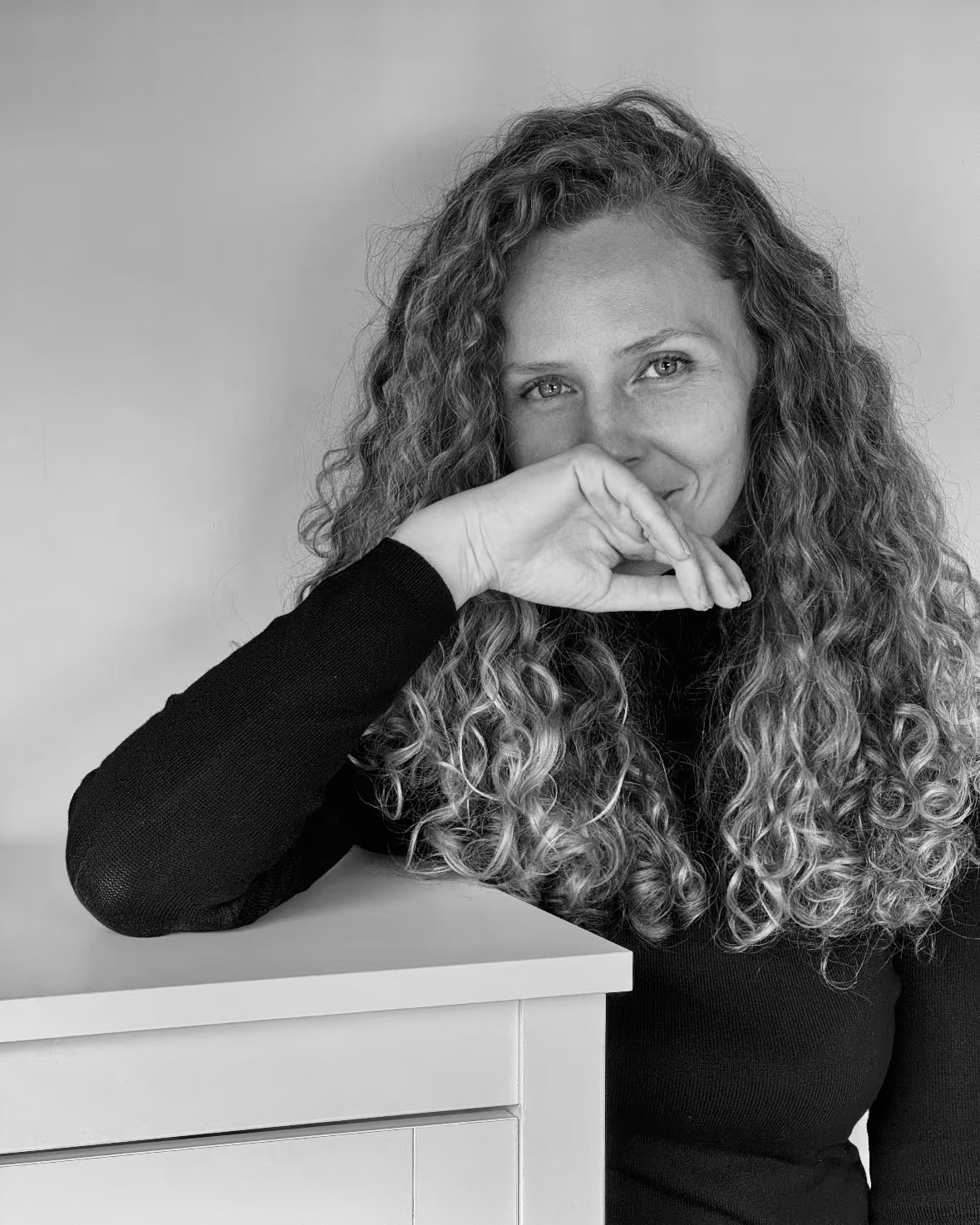 Black and white portrait of Tanya, live event artist in Auckland, New Zealand, leaning on a surface, Revastique illustration services